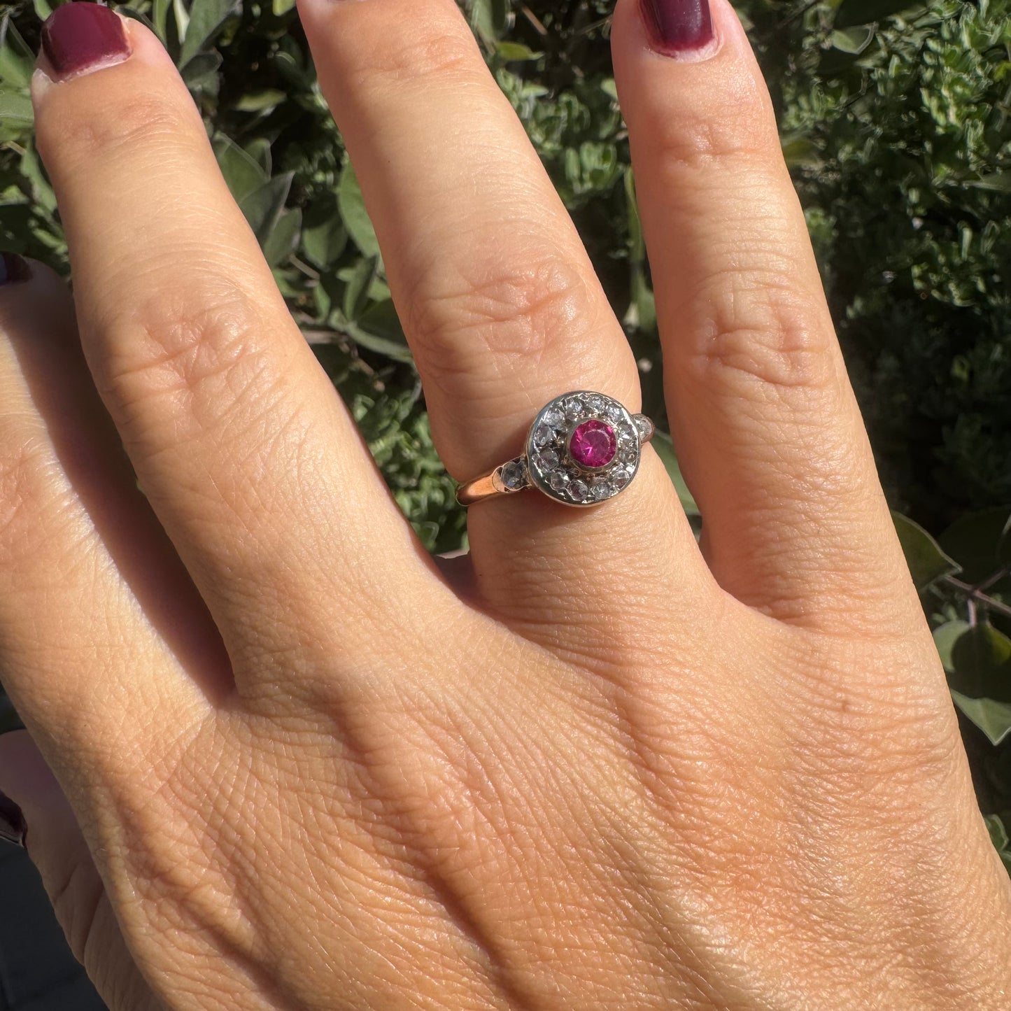 18K gold ring set with a round Ruby at the center, surrounded by a halo of old-cut Diamonds.
