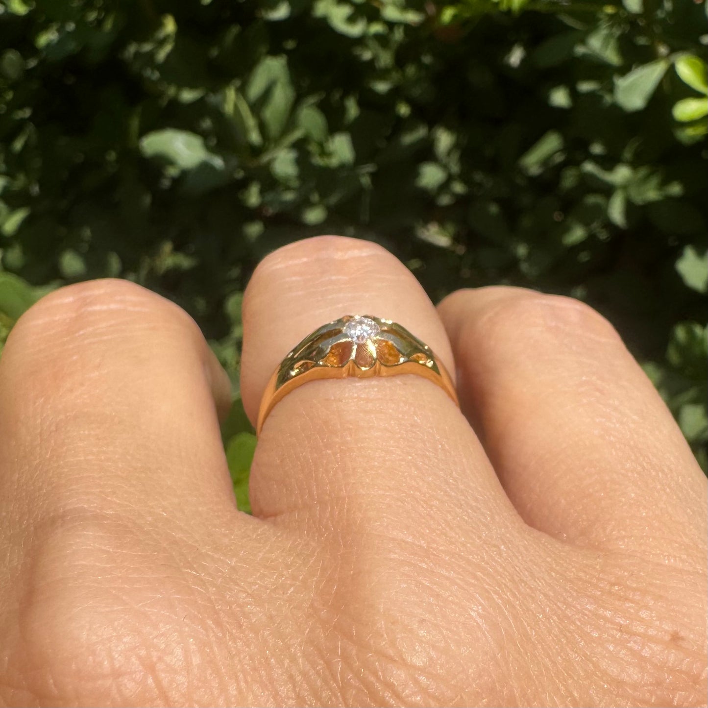 18K gold ring set with a small sparkling diamond at the center.