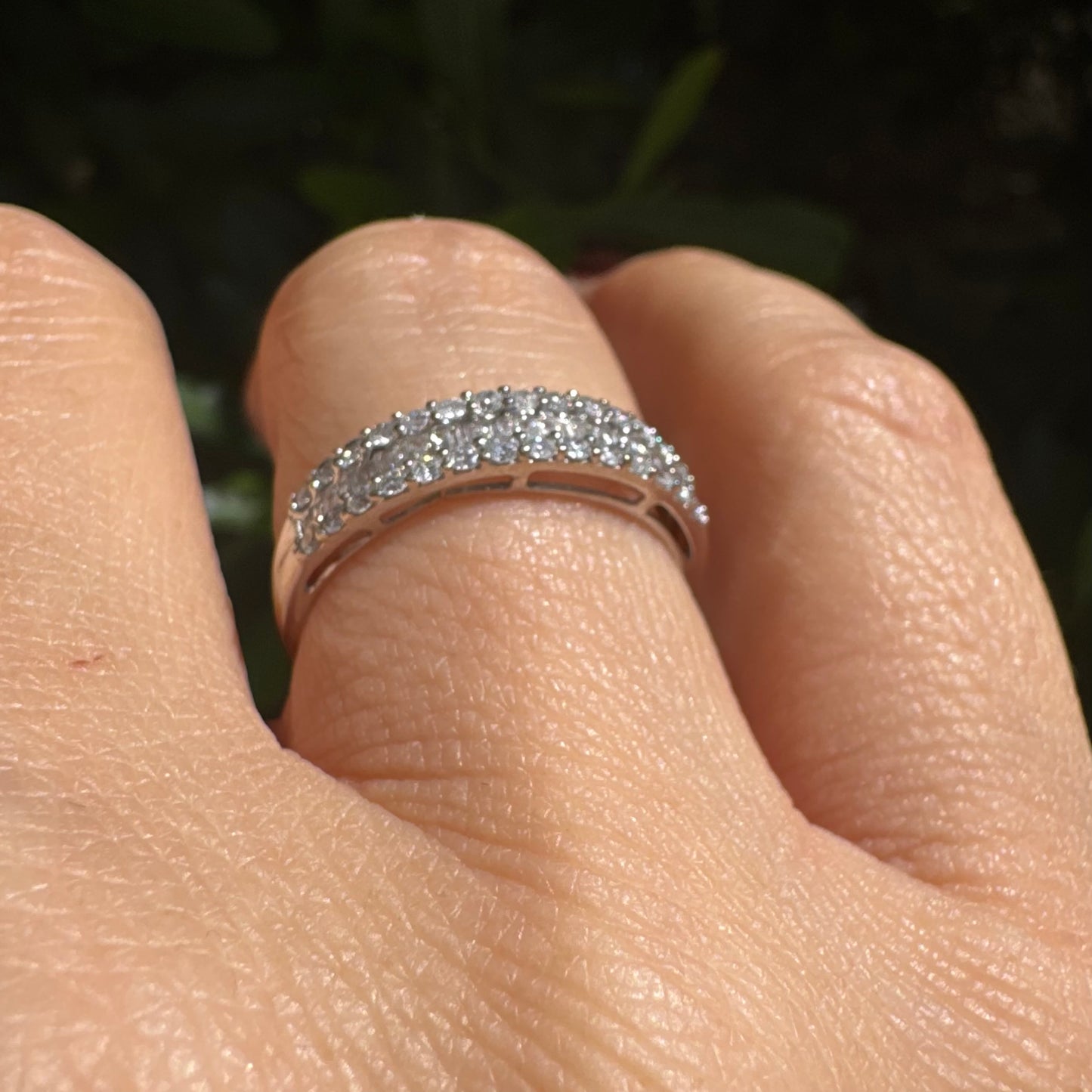 14K gold ring set with a row of baguette-cut diamonds framed by two rows of brilliant round diamonds