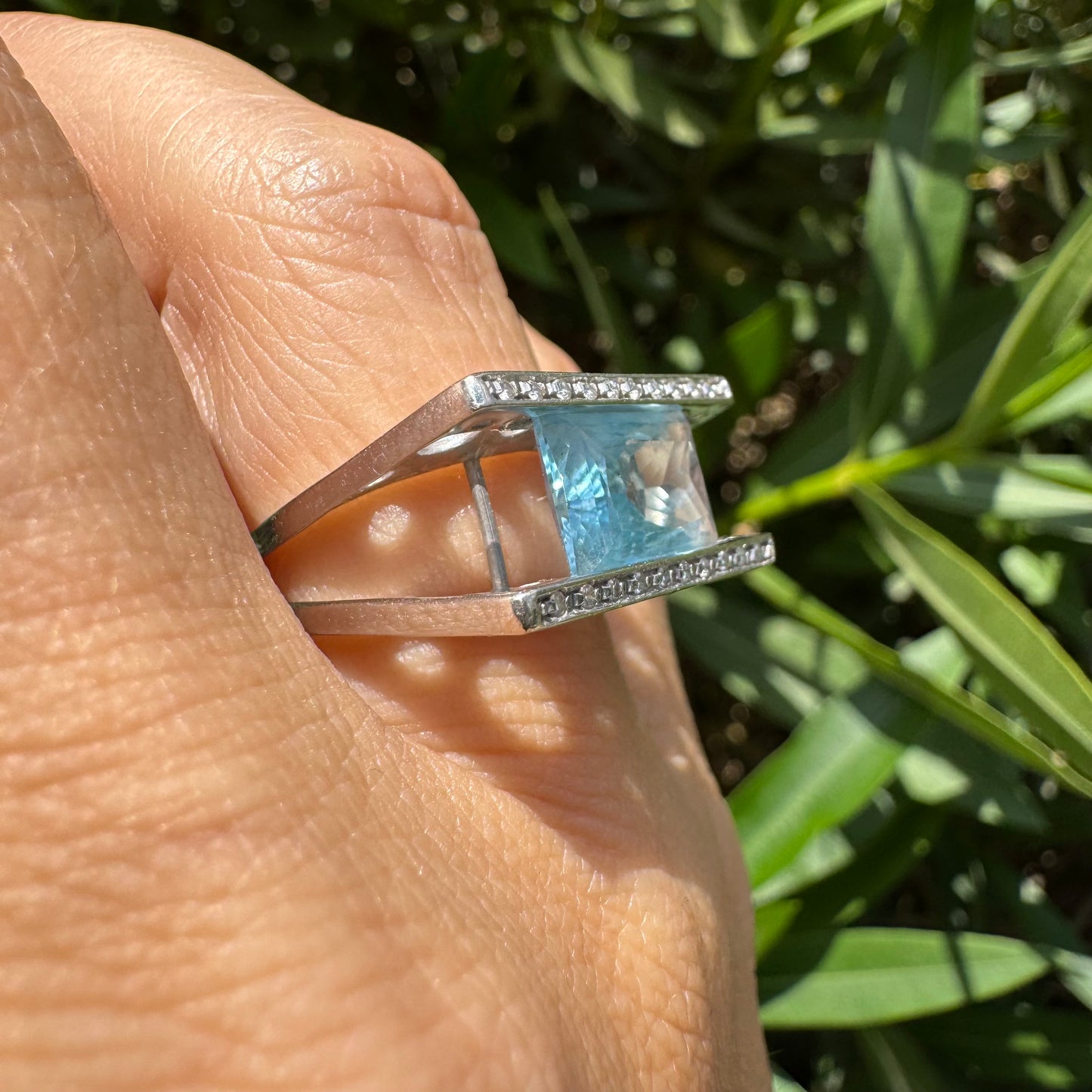 18K gold ring set with a stunning Aquamarine centerpiece held between two sleek gold bars set with delicate Diamonds.