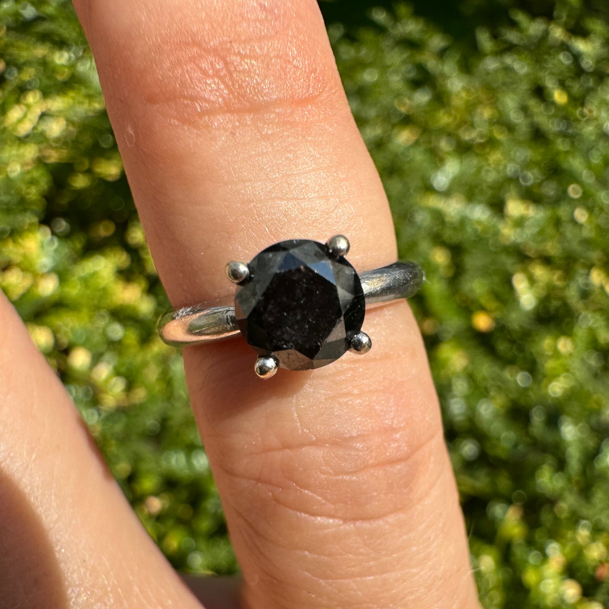 טבעת סוליטר זהב לבן 10 קראט אלגנטית ובעלת נוכחות, משובצת ביהלום שחור בחיתוך עגול במסגרת קלאסית בעלת ארבע שיניים מזהב לבן.