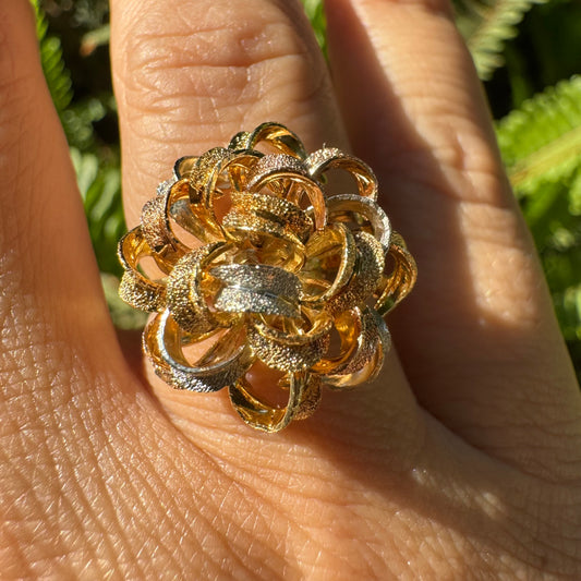 18K gold ring set with intricately textured loops in yellow, white, and rose gold, forming a bold floral-inspired sculptural design.