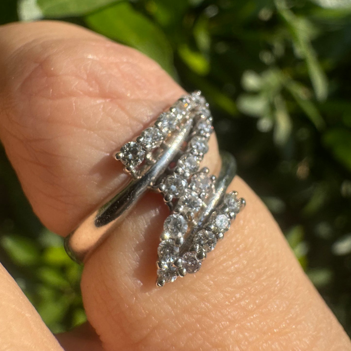 14K gold ring with an open design, featuring two curved rows of sparkling Diamonds that cross over each other elegantly.