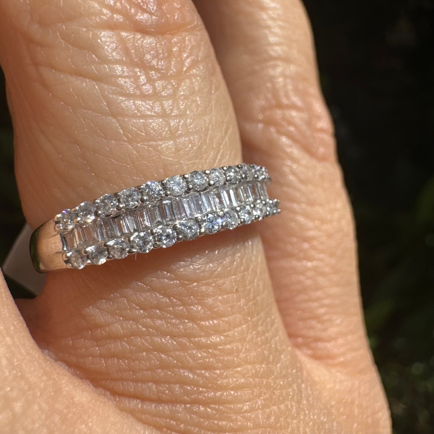 14K gold ring set with a row of baguette-cut diamonds framed by two rows of brilliant round diamonds