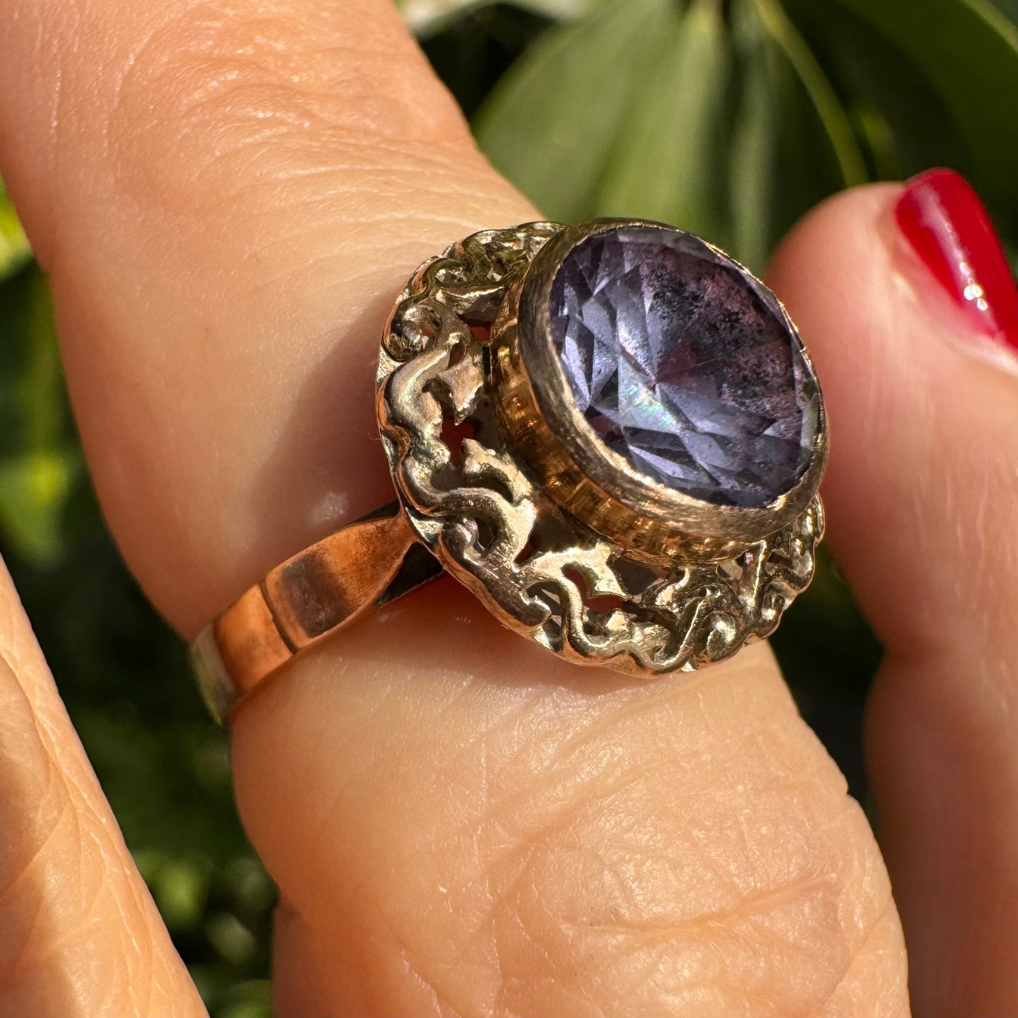 14K gold ring set with a large round-cut Tanzanite framed by an ornate filigree bezel