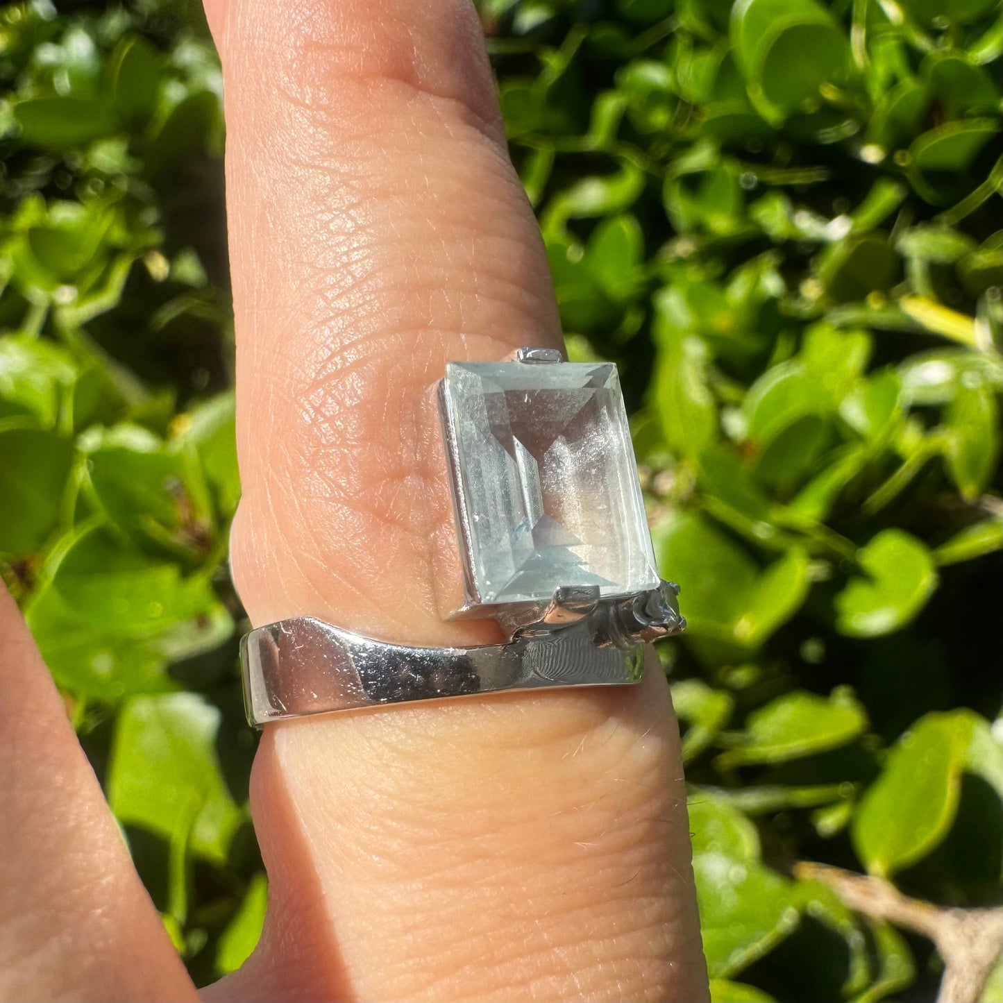 18K gold ring set with a rectangular step-cut Aquamarine set in a sculptural white gold band & a sparkling Diamond