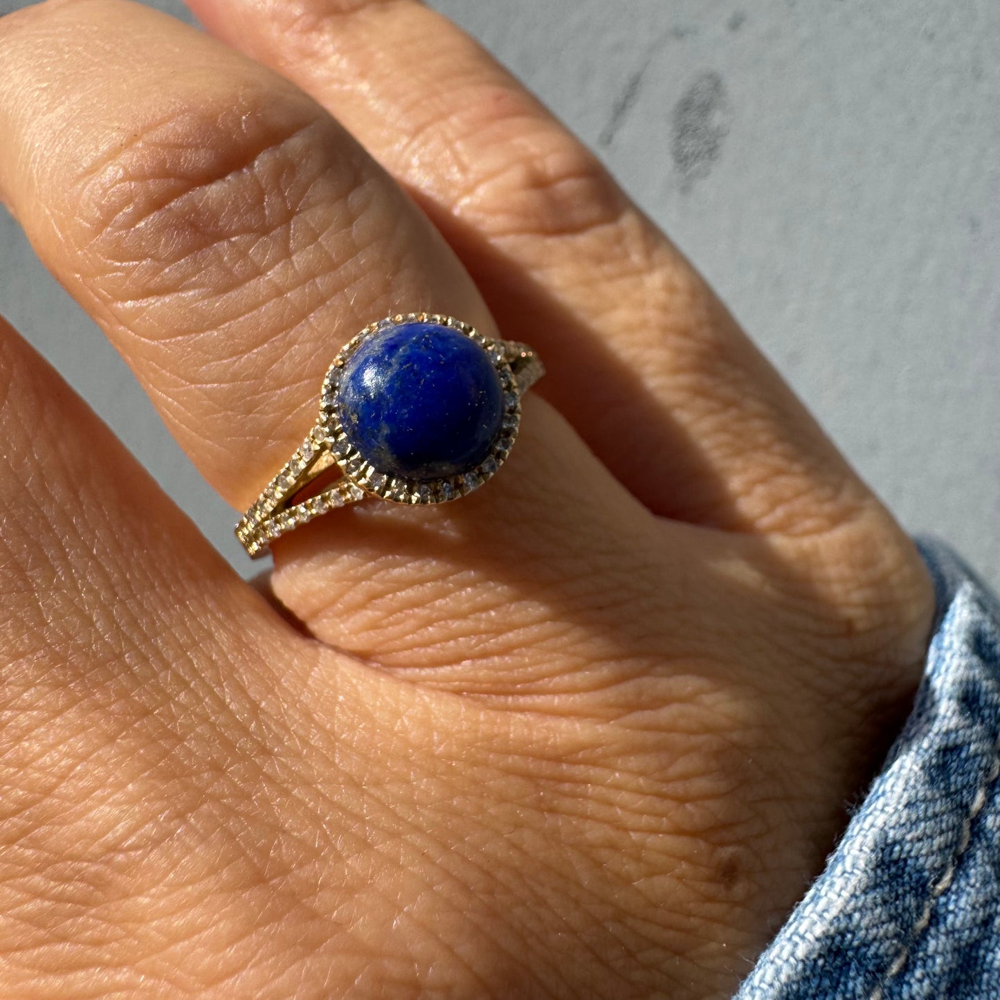 14K gold ring set with a round Lapis Lazuli gemstone, surrounded by a delicate halo of sparkling Diamonds.