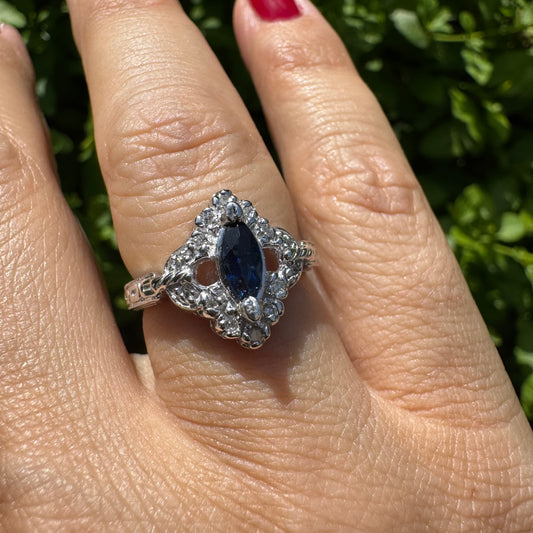 טבעת זהב לבן 14 קראט משובצת אבן ספיר בצבע כחול כהה בחיתוך מרקיזה ויהלומים מסביב