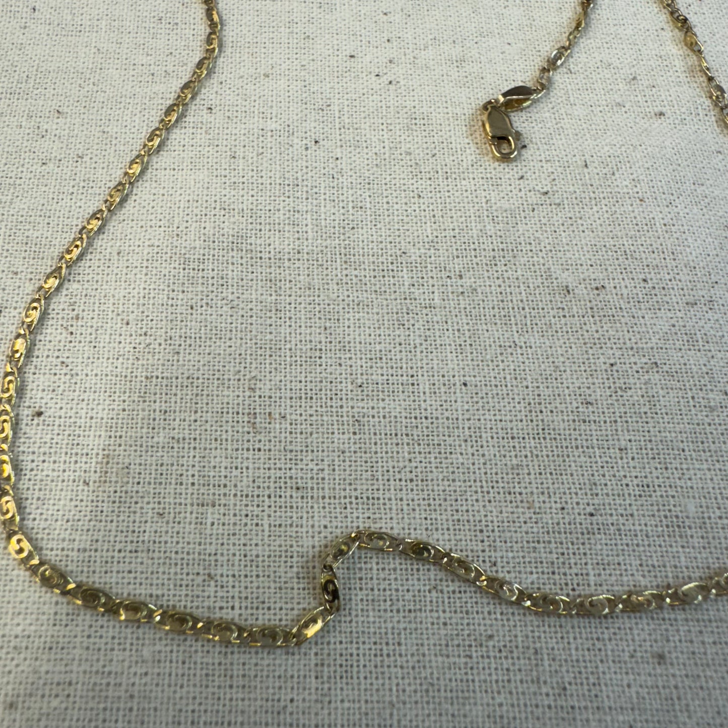 14K gold necklace featuring oval-shaped links with a subtle decorative pattern.