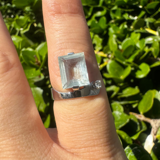 טבעת זהב לבן 18 קראט משובצת אבן אקוומרין גדולה בליטוש מלבני (חיתוך אמרלד), לצד יהלום קטן ועגול שמוסיף ניצוץ מדויק.