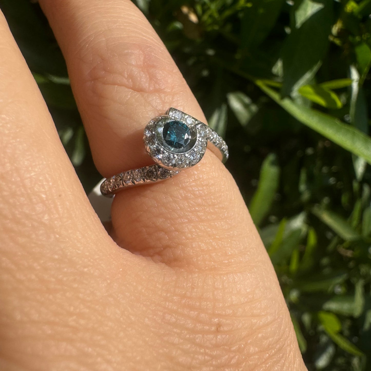 18K gold ring set with a vivid blue Diamond at its heart, embraced by a shimmering halo of white diamonds and a bold open design