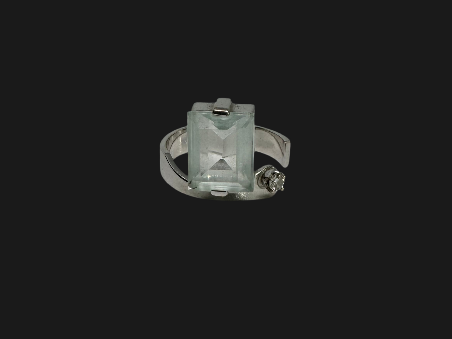 18K gold ring set with a rectangular step-cut Aquamarine set in a sculptural white gold band & a sparkling Diamond