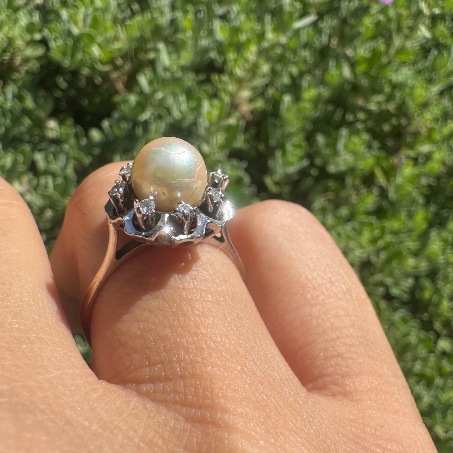 18K gold ring set with a round Pearl at the center, surrounded by a floral halo set with small Diamonds.
