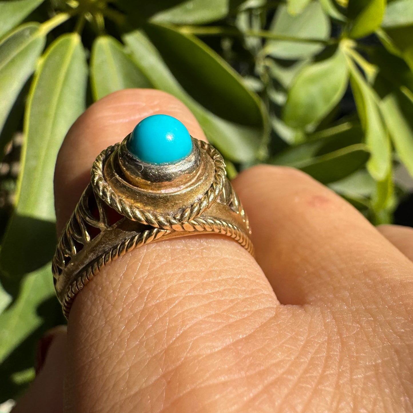14K gold ring set with a round Turquoise stone at its center framed by a double rope-style bezel