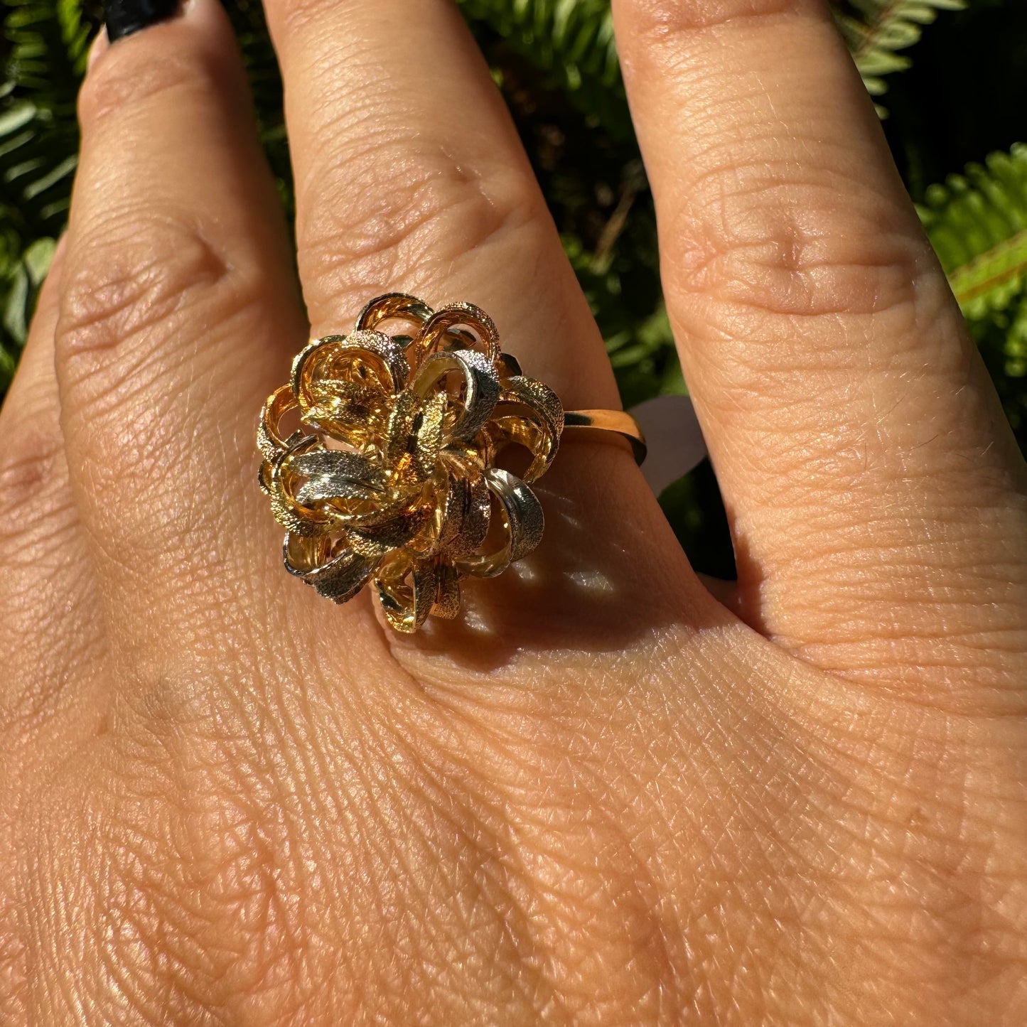 18K gold ring set with intricately textured loops in yellow, white, and rose gold, forming a bold floral-inspired sculptural design.