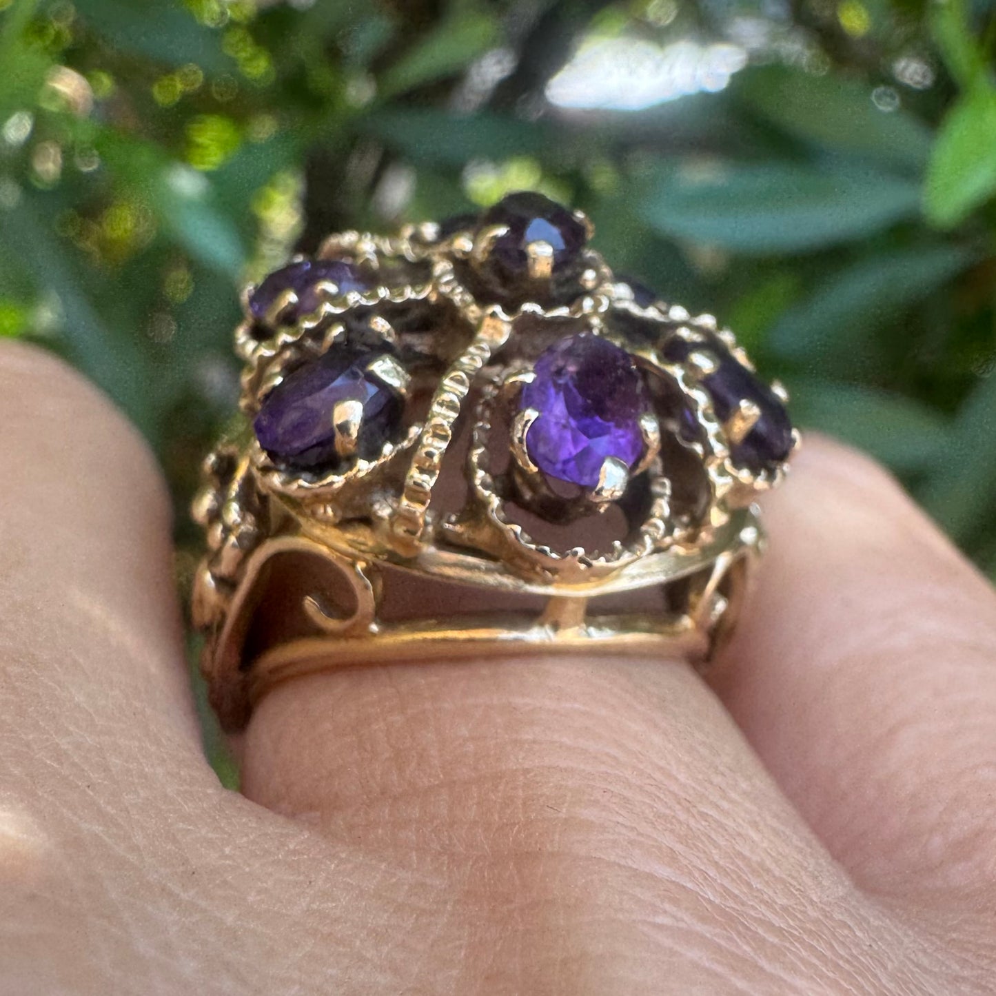 14K gold ring set with deep purple amethysts in an ornate floral design.
