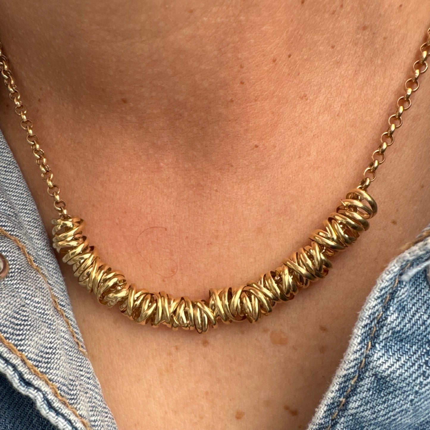 14K gold necklace featuring a series of intertwined gold rings creating a bold and sculptural design.