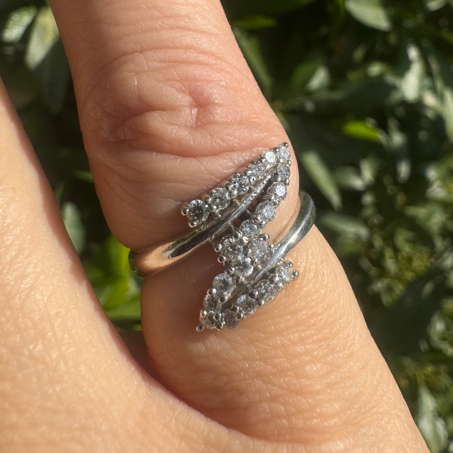 14K gold ring with an open design, featuring two curved rows of sparkling Diamonds that cross over each other elegantly.