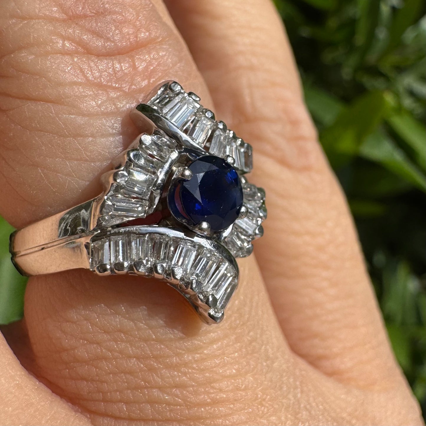 14K gold ring set with a round deep blue sapphire at the center, surrounded by baguette cut Diamonds