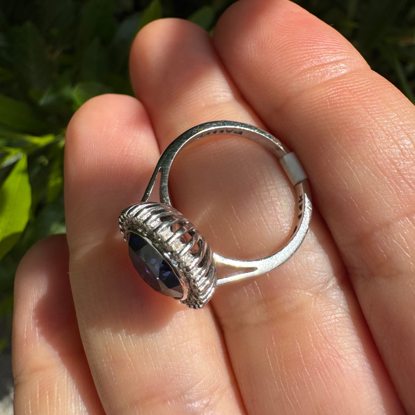 14K gold ring set with a deep blue oval Sapphire surrounded by a halo of sparkling Diamonds