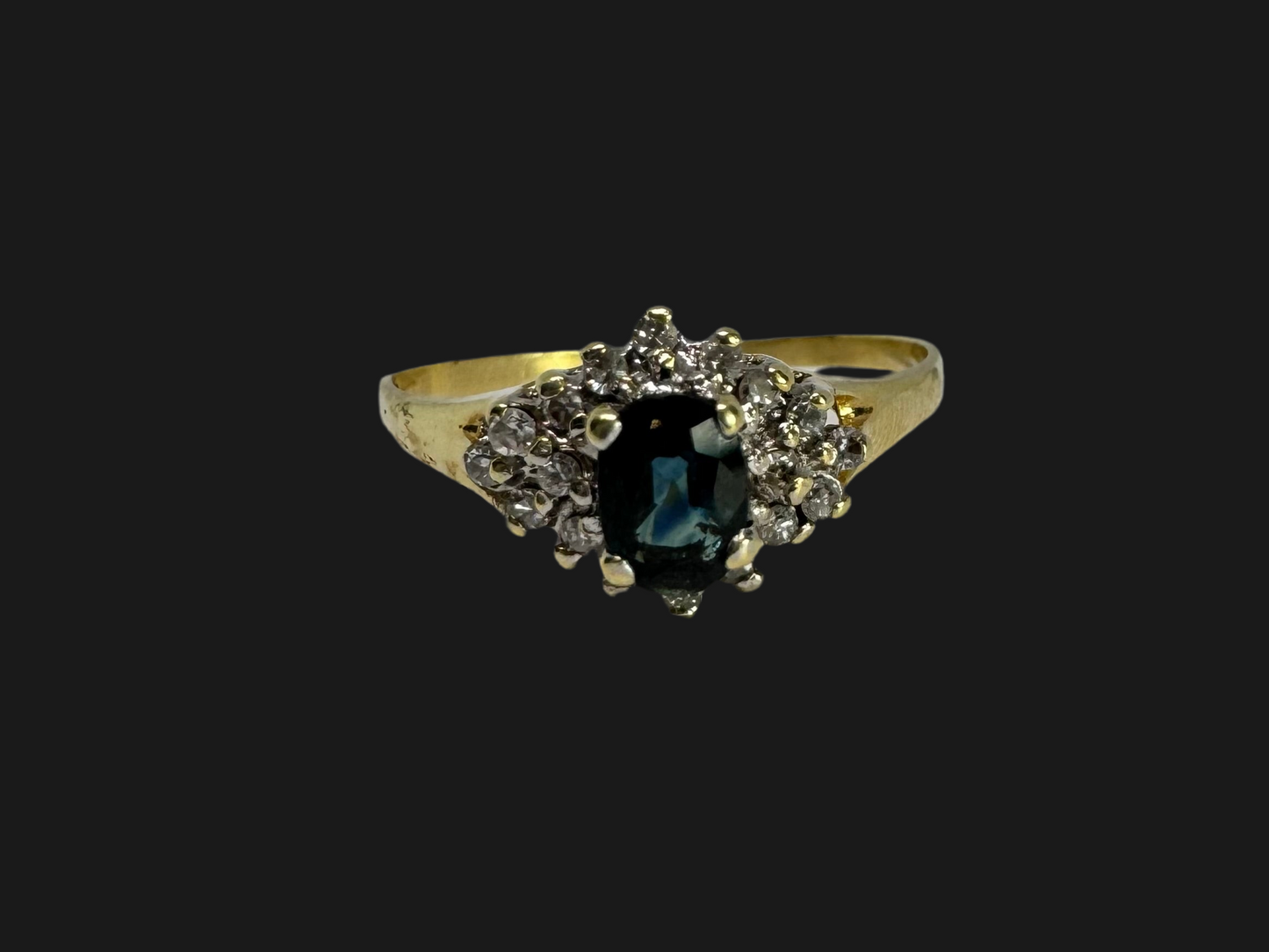 14K gold ring set with an oval blue Sapphire surrounded by sparkling Diamonds