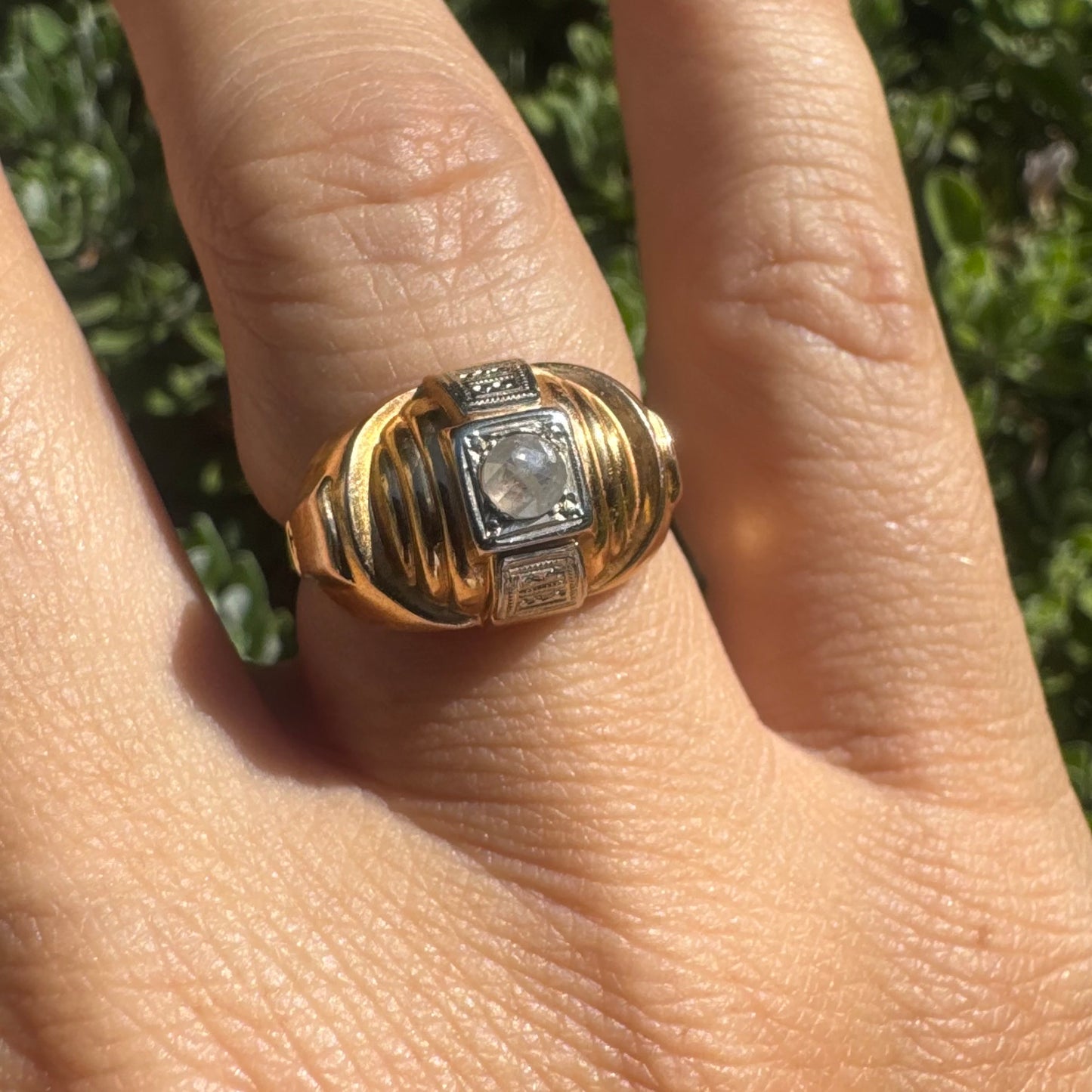 18K gold ring featuring a central round Diamond set in a square bezel with decorative details.