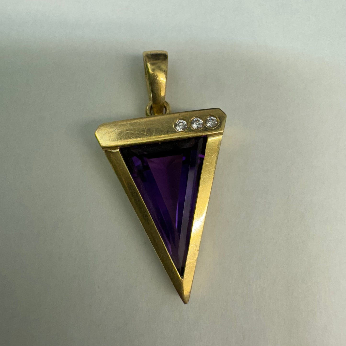 14K yellow gold pendant set with a triangular-cut amethyst and three accent diamonds