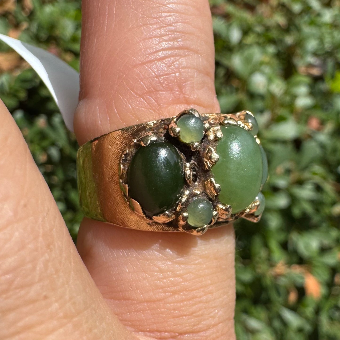 14K gold ring set with a central oval green Jade cabochon, framed by additional Jade stones in varying shades and sizes