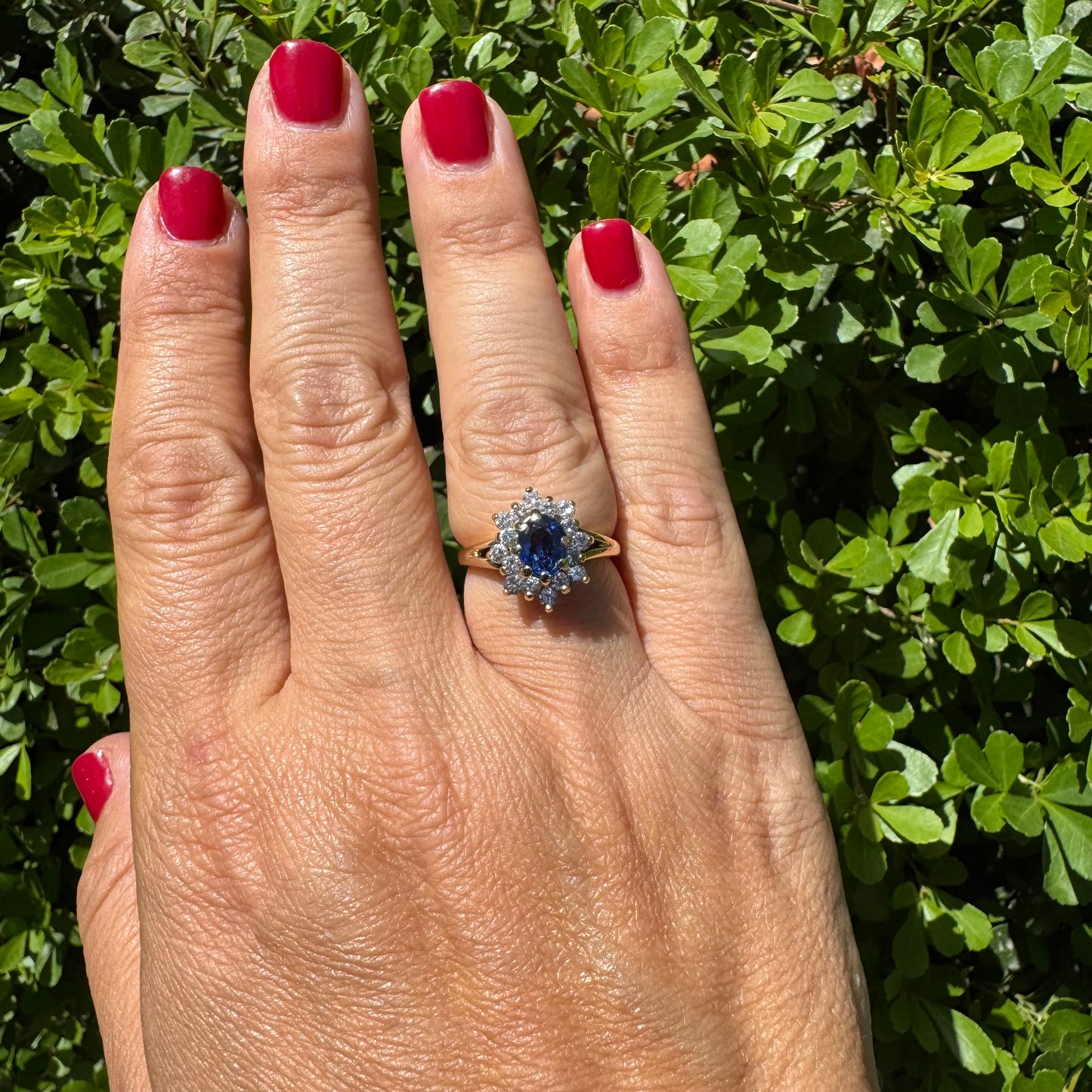 14K gold ring set with a vivid blue Sapphire surrounded by a sparkling halo of brilliant-cut Diamonds