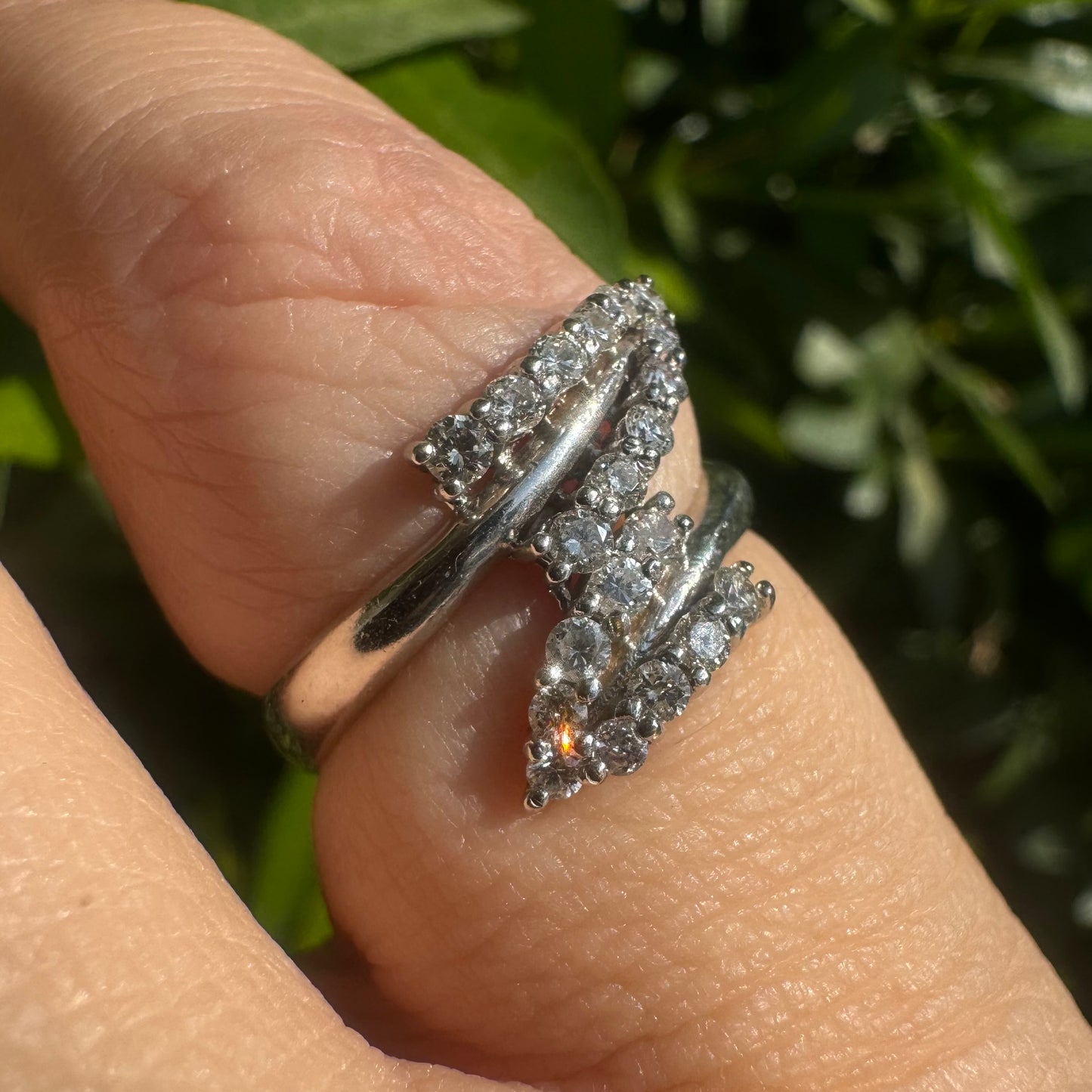 14K gold ring with an open design, featuring two curved rows of sparkling Diamonds that cross over each other elegantly.