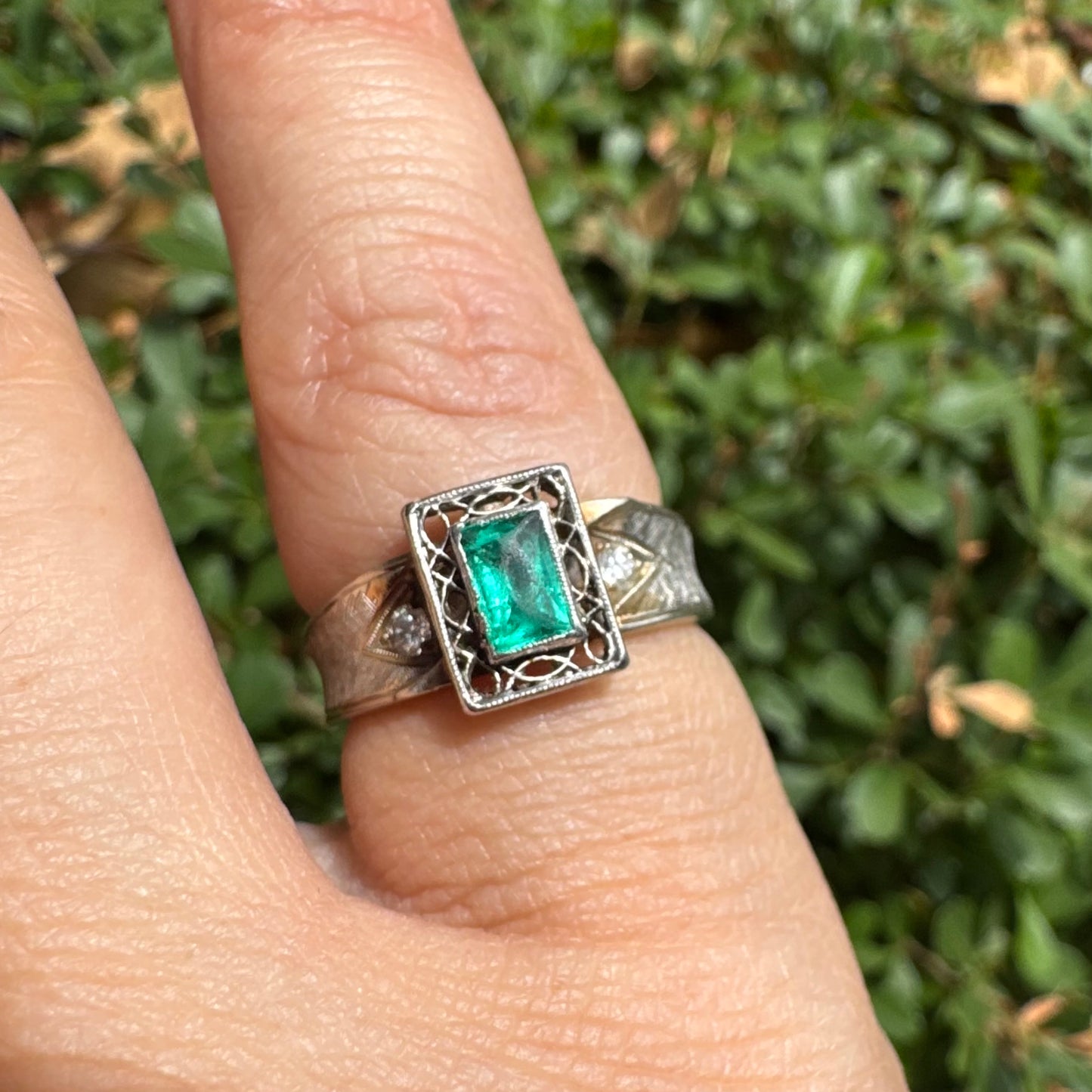14K gold ring set with a vibrant emerald-cut Emerald at its center, framed by delicate filigree work