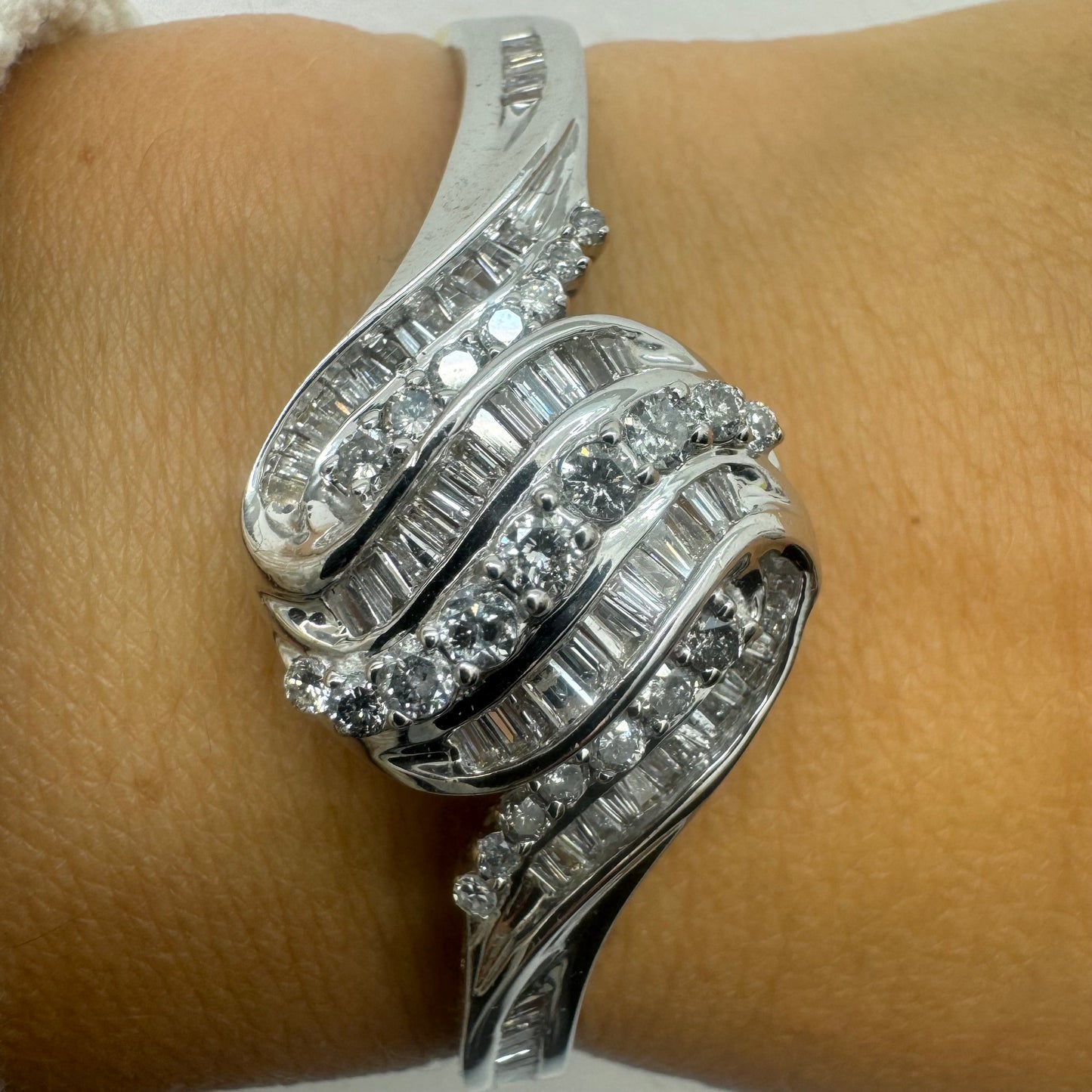 צמיד מרהיב מזהב לבן 14 קראט, בעיצוב גלים דינמי המשובץ בשיבוץ מרוכב של יהלומים עגולים ובחיתוך באגט.