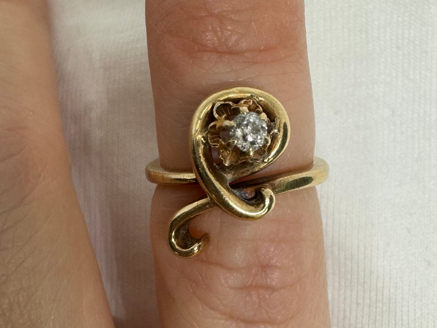 14K gold ring set with a brilliant-cut Diamond, embraced by a flowing, sculptural gold design
