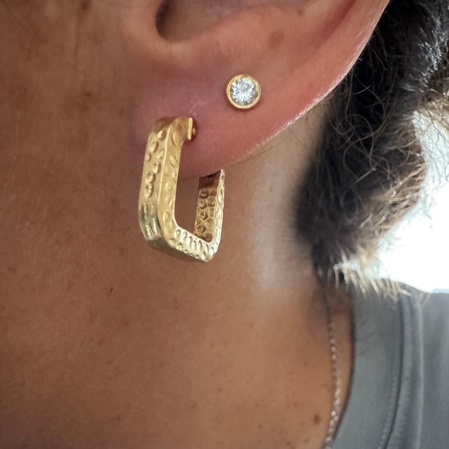 עגילי חישוק מרובעים מזהב 14 קראט בגימור מחוספס ומטאלי.