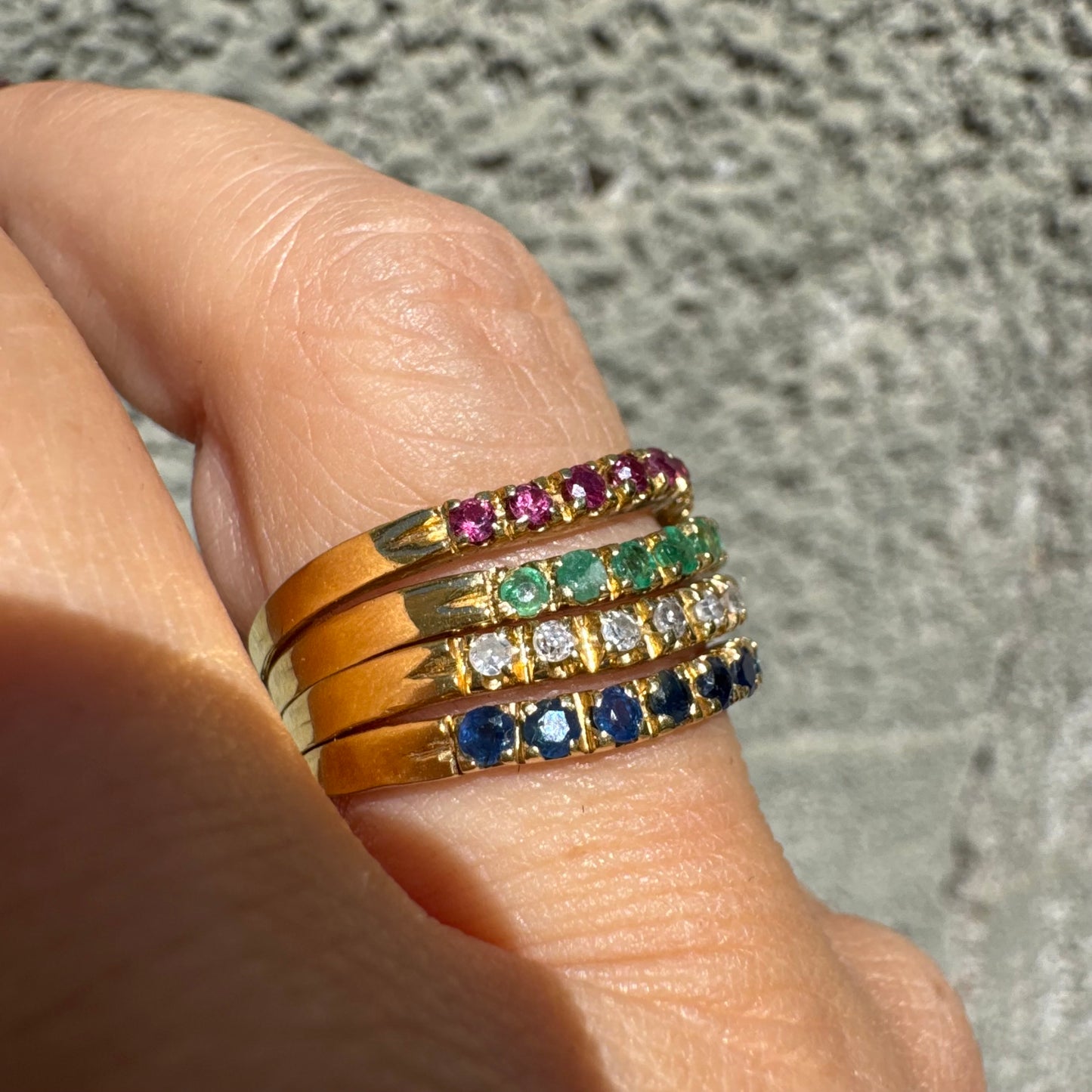 18K yellow gold ring set with vibrant rows of Sapphires, Emeralds, Rubies, and Diamonds
