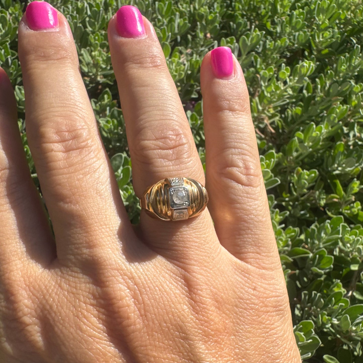 18K gold ring featuring a central round Diamond set in a square bezel with decorative details.