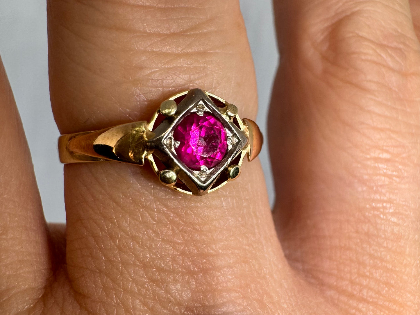 14K gold ring set with a vivid round-cut Ruby set in a geometric white gold frame.