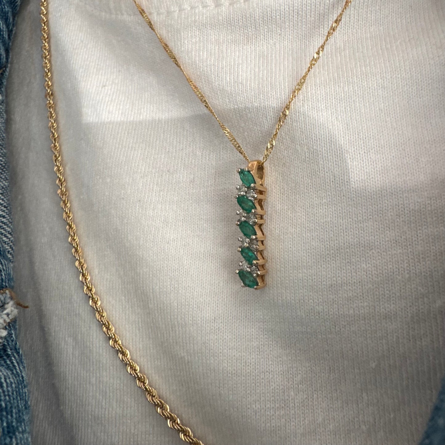 תליון זהב 14 קראט משובץ אמרלדים בחיתוך מרקיזה ויהלומים נוצצים.