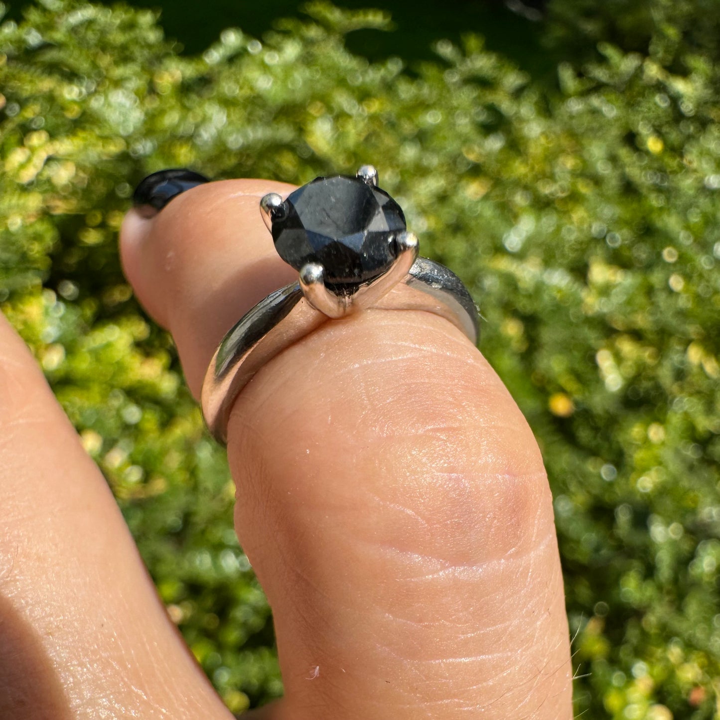 טבעת סוליטר זהב לבן 10 קראט אלגנטית ובעלת נוכחות, משובצת ביהלום שחור בחיתוך עגול במסגרת קלאסית בעלת ארבע שיניים מזהב לבן.