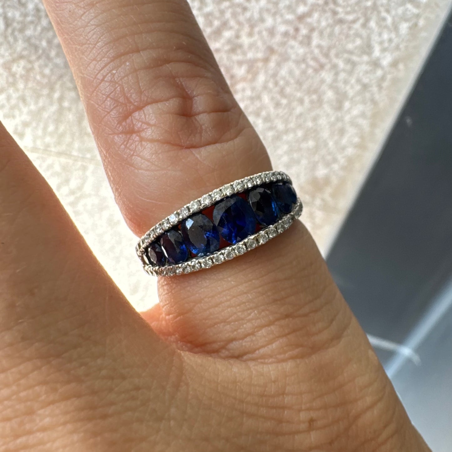 טבעת זהב צהוב 18 קראט משובצת שורת אבני ספיר כחולות בליטוש אובלי, משובצות במרכז ומוקפות בשתי שורות של יהלומים אחת מעל ואחת מתחת.