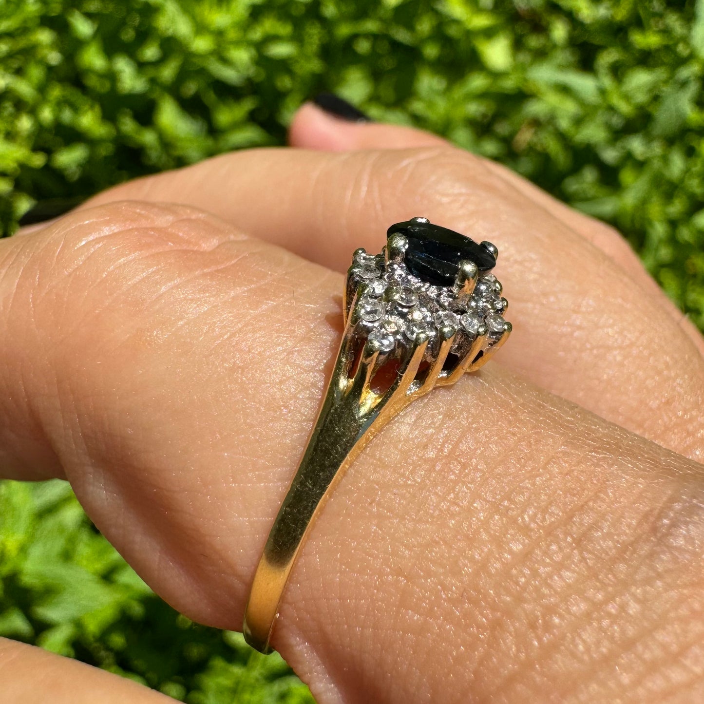 14K gold ring set with an oval blue Sapphire surrounded by sparkling Diamonds