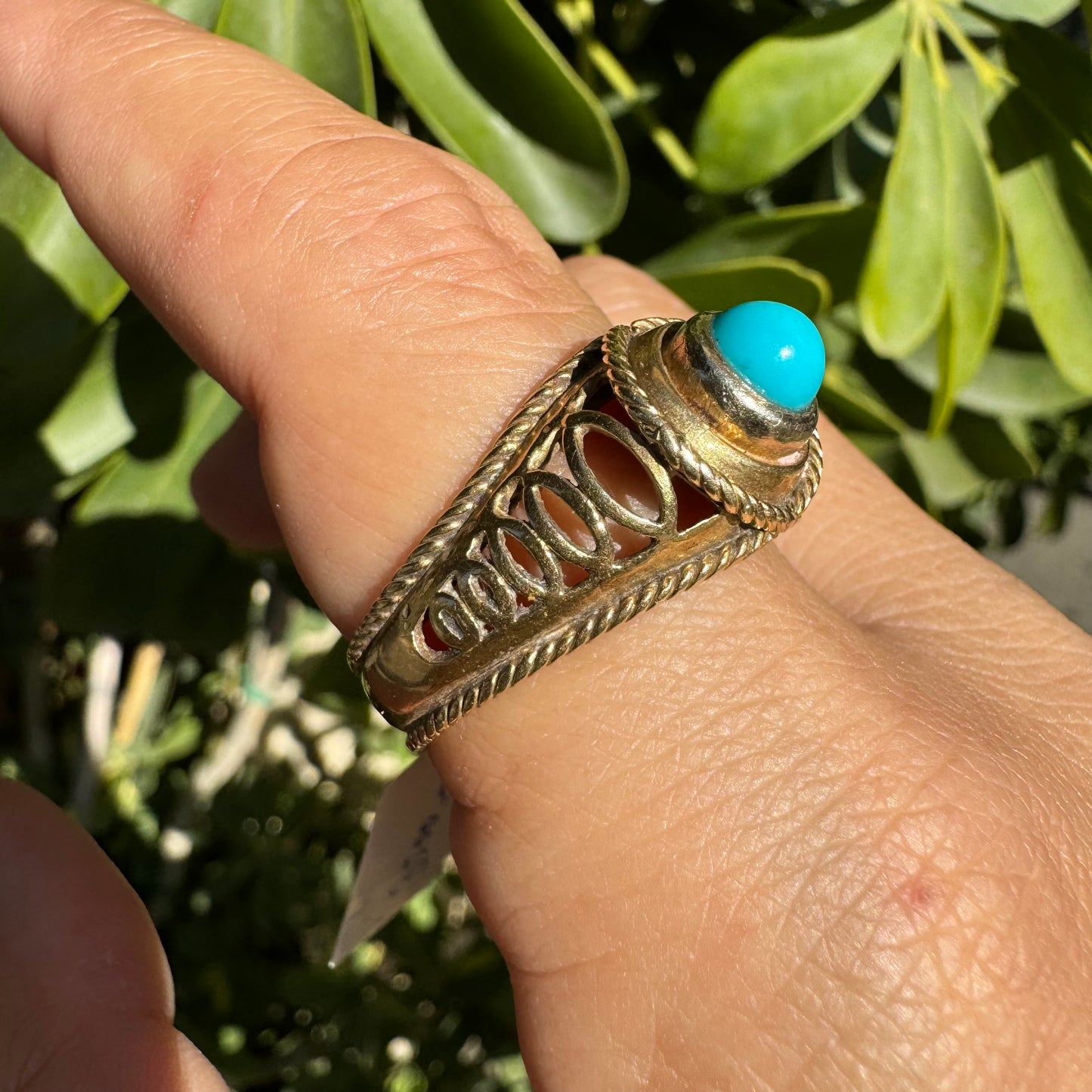 14K gold ring set with a round Turquoise stone at its center framed by a double rope-style bezel