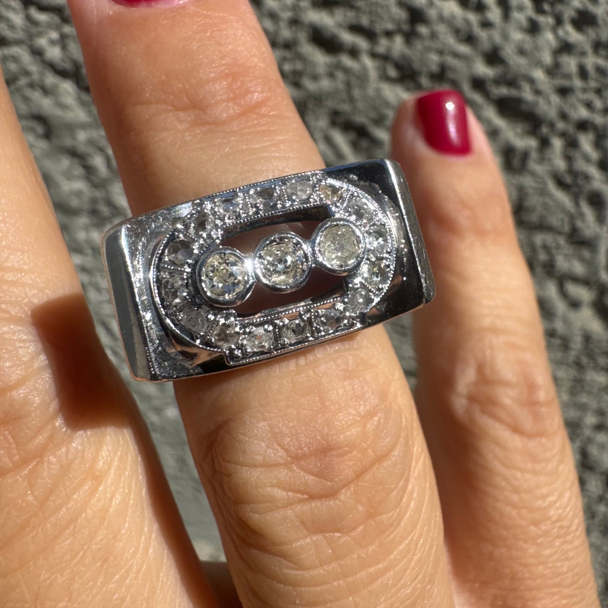 טבעת זהב לבן 18 קראט רחבה, משובצת שלושה יהלומים עגולים במרכז, מוקפים במסגרת מלבנית המשובצת יהלומים