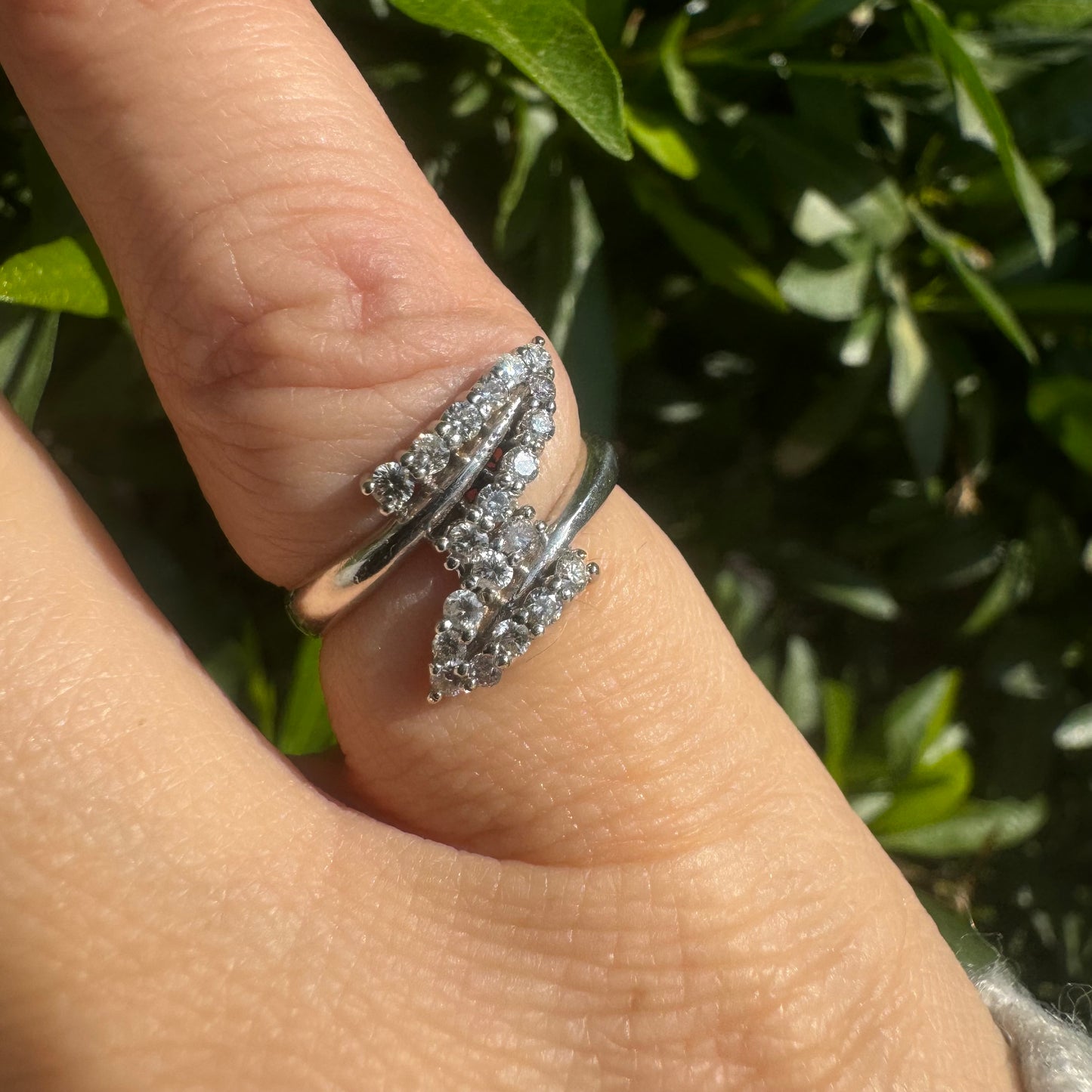 14K gold ring with an open design, featuring two curved rows of sparkling Diamonds that cross over each other elegantly.