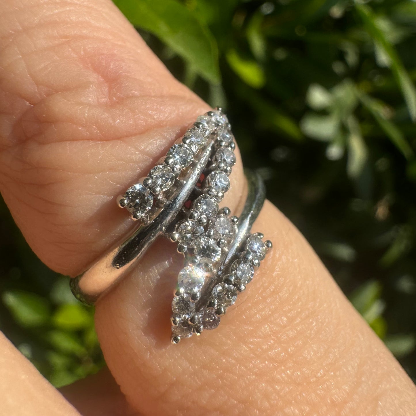 14K gold ring with an open design, featuring two curved rows of sparkling Diamonds that cross over each other elegantly.