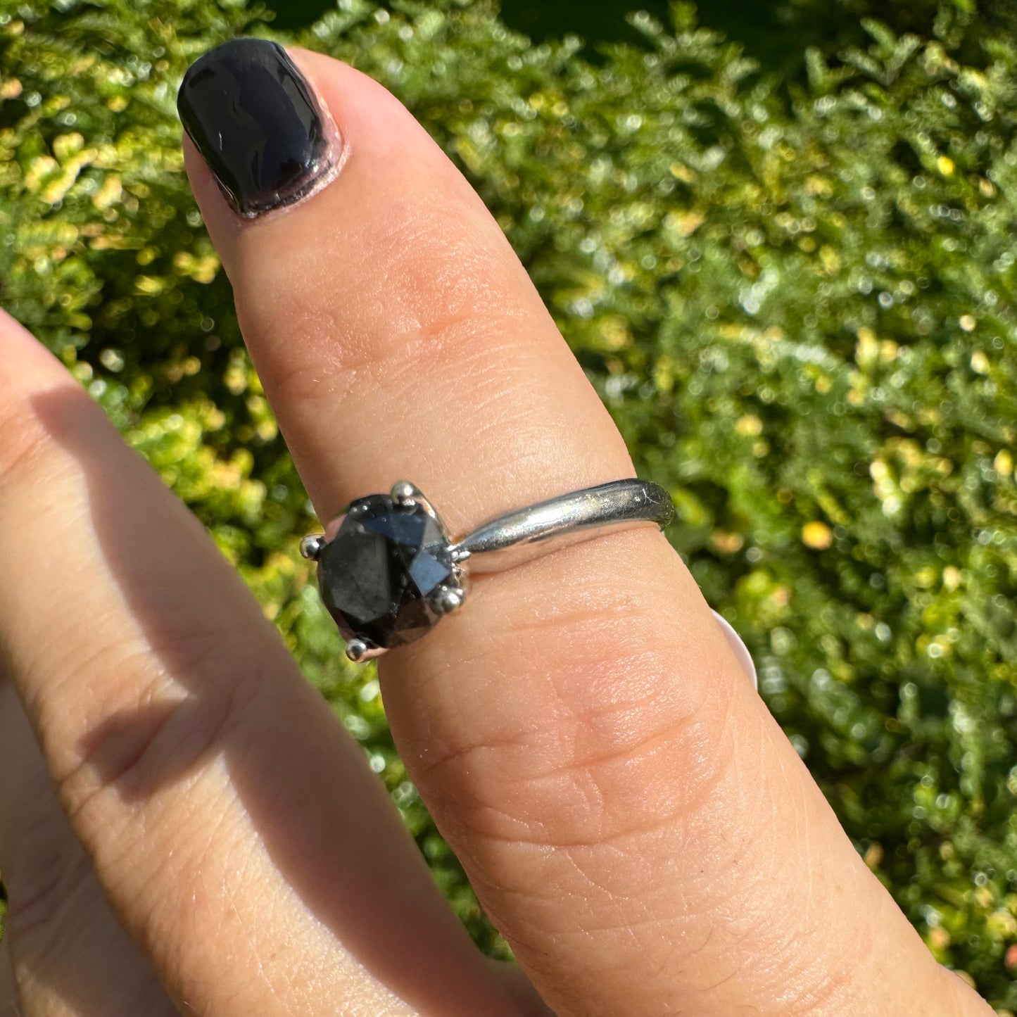 טבעת סוליטר זהב לבן 10 קראט אלגנטית ובעלת נוכחות, משובצת ביהלום שחור בחיתוך עגול במסגרת קלאסית בעלת ארבע שיניים מזהב לבן.