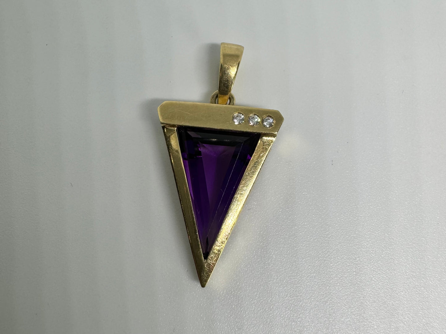 14K yellow gold pendant set with a triangular-cut amethyst and three accent diamonds