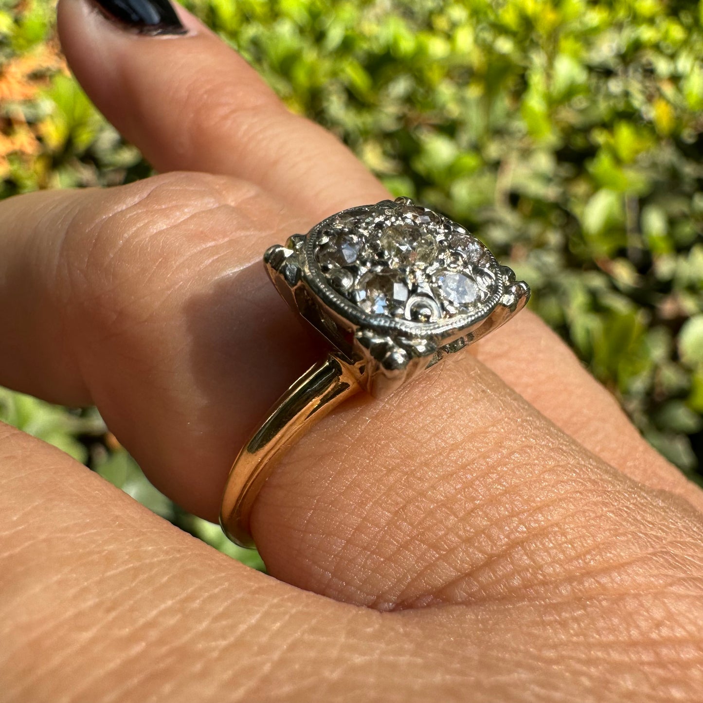 14K gold ring set with an old-cut Diamond at its center, encircled by a pavé cluster of smaller Diamonds in a round, ornate setting.