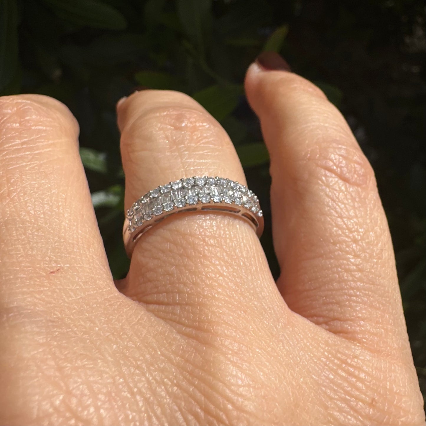 14K gold ring set with a row of baguette-cut diamonds framed by two rows of brilliant round diamonds