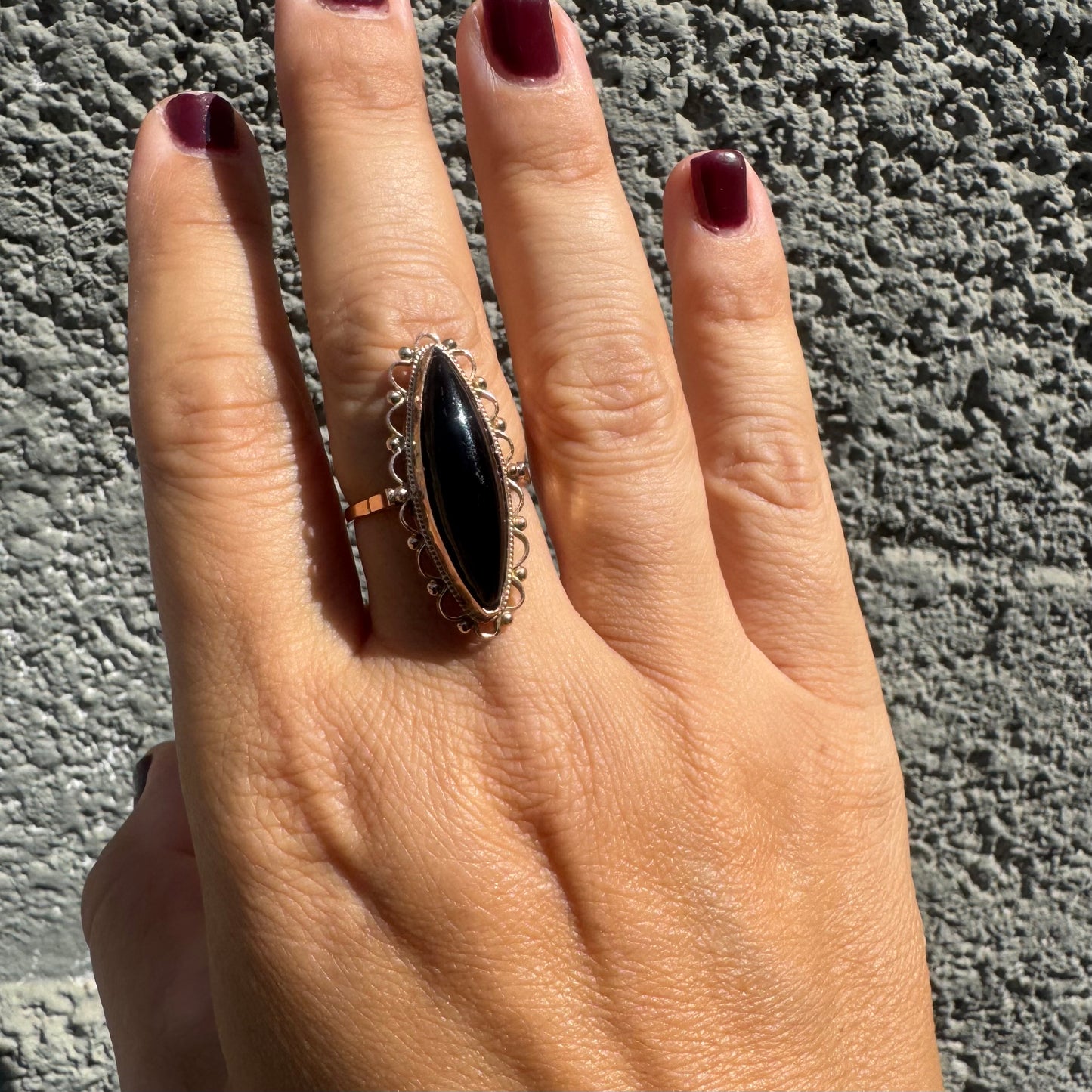 14K gold ring featuring a long marquise-shaped black Onyx stone, framed with delicate decorative details around the setting.